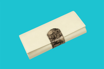 Leather purse on light blue background. Beige clutch with chain inside. Female shoulder bag, close up. Fashion and style concept