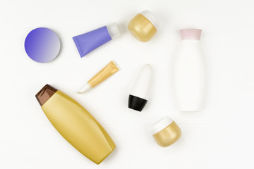 Plastic bottles of body care and beauty products on white. Flat lay