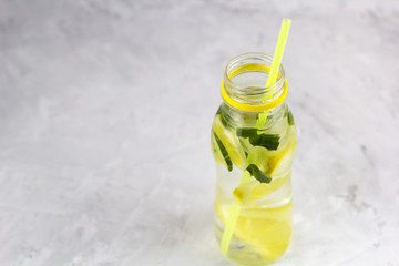 water with lemon ,cucumber and aloe vera  in bottle with cocktail straw copy space