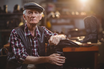 Portrait of shoemaker holding a shoemaker stand