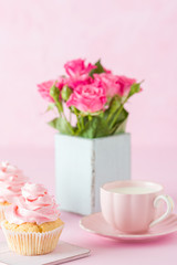 Pink pastel vertical banner with decorated cupcakes, cup of coffe with milk and bouquet of pink roses.