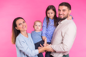 Happy mixed race family portrait smiling on pink background