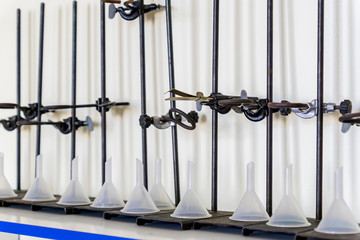 Laboratory equipment in a row - test tube holder, Clamps, plastic fiunnels