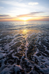 Coastal waves at sunset. Colorful sunset on a sea beach.