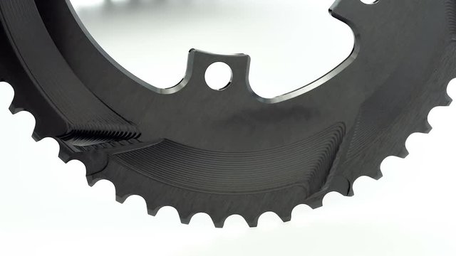 Black oval bicycle chainring gear rotating at white background