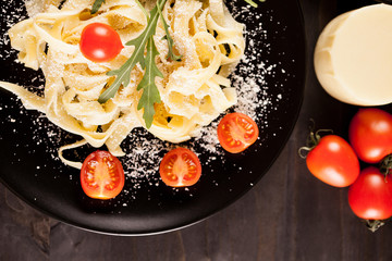 Plate with healthy and delicious italian pasta on wooden background