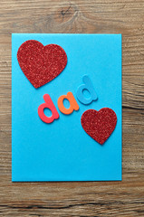 The word dad on a blue note with two red hearts