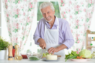 Senior man  preparing dinner in kitchen