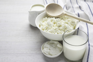 dairy products, cottage cheese, milk in a glass, yogurt, sour cream in a white dish on a white background.
