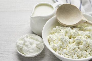 dairy products, cottage cheese, milk, yogurt, sour cream in white dishes close-up.