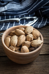Almonds in-shell in wooden bowl.