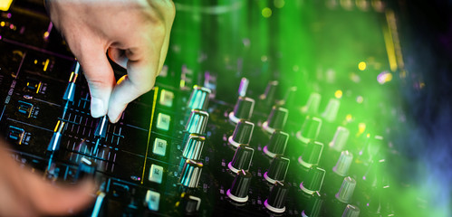 Dj mixes the track in the nightclub at a party
