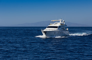 Fototapeta na wymiar Boat in deep blue water, Santorini, Greece.