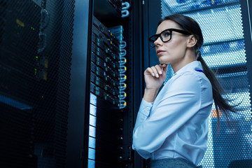 Thinking. Determined meditative woman working with equipment and thinking