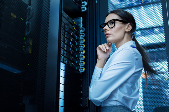 Thinking. Determined meditative woman working with equipment and thinking