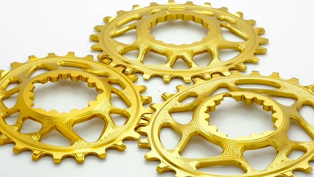  Golden oval bicycle chainring gear rotating at white background