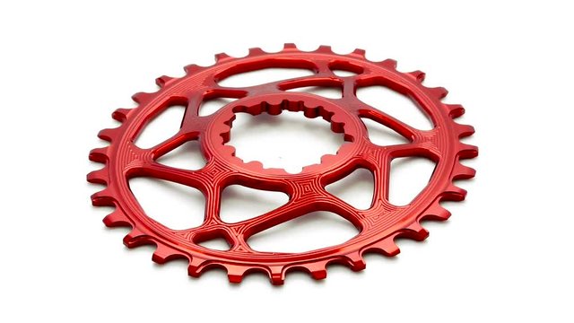 Red oval bicycle chainring gear rotating at white background