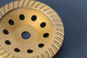 The diamond grinding wheel on a gray granite background.