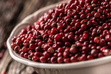 Red peppercorn in bowl on oak table