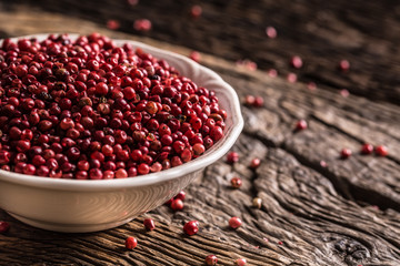 Red peppercorn in bowl on oak table