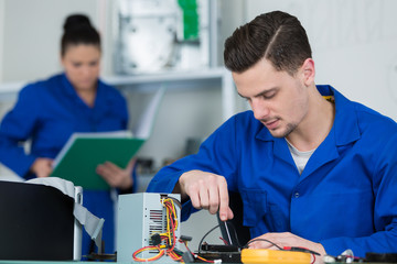 team of students examining and repairing computer parts