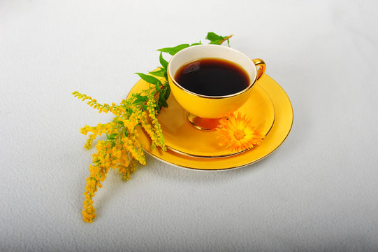 Gul kaffekopp og blomster