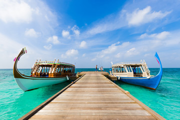 Maldives Dhoni boat in blue sea and wooden jetty