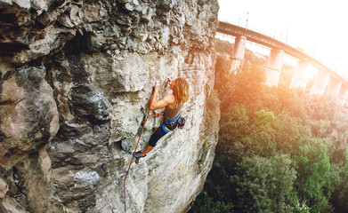 woman rock climber climbs on the cliff
