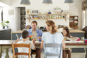 White family of four eating lunch in their kitchen at home