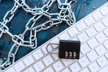 GDPR - General Data Protection Regulation concept with computer motherboard, white keyboard, metallic chain and padlock
