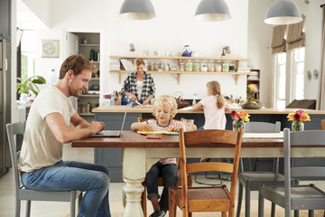 Young white family busy working in their kitchen