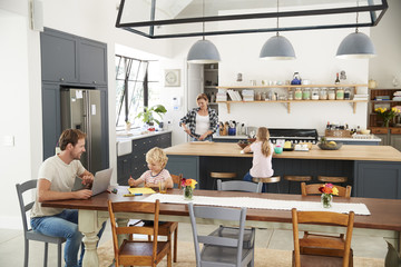 Fototapeta na wymiar Young white family busy in their kitchen, elevated view