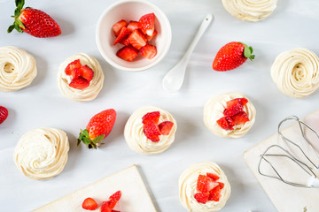Meringues Pavlova cakes with strawberry. Flat lay, top view