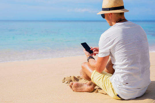 Man on the beach with mobile phone