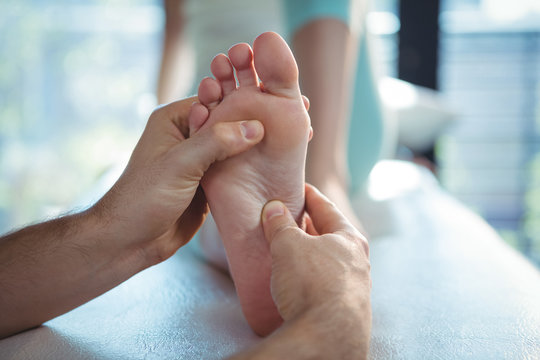 Male physiotherapist giving foot massage to female patient