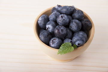 Berries of blueberries in a wooden bowl