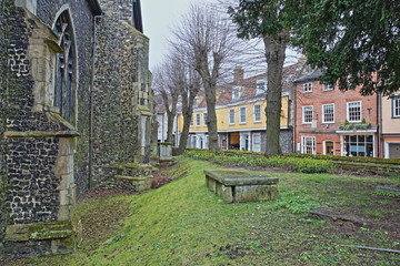 Elm Hill cobbled street with medieval houses from the Tudor period with St Simon and St Jude Chuch on the left in Norwich, Norfolk, UK