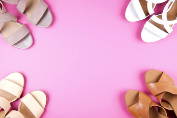 Stylish composition with multiple classic women's leather sandals shoes with medium heels, different styles, on pale pink background. Copy space, top view, flat lay. Shoe sale / clearance ad concept.