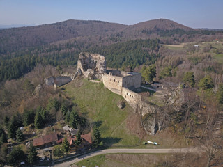 Fototapeta premium Kamenets, near Odjykon, Poland -april 8, 2018: Ancient ruins of a medieval castle against the backdrop of a natural landscape of the central strip of central Europe. View of drone. Panorama of fly.