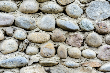 Background from a brown natural round stone wall