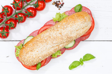 Sandwich Baguette Vollkorn Brötchen belegt mit Salami von oben auf Holzbrett