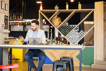 Successful young businessman working in a modern cafe