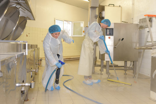 factory worker cleaning floor