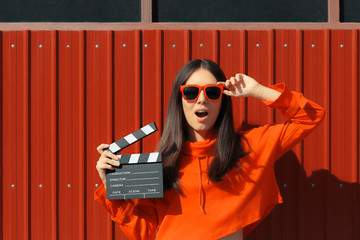 Beautiful Woman with Cinema Clapper on Red Background 