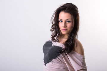 Naklejka premium Beautiful young brunette woman posing in studio before white wall