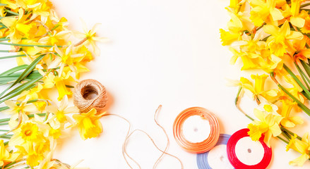 the yellow flowers are daffodils and colored tape with a length of rope on a white background, top view. mock up for text, for phrases, for lettering