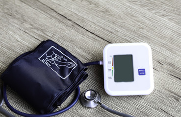 Digital Blood Pressure Monitor on  Wooden background Health and Medical concept