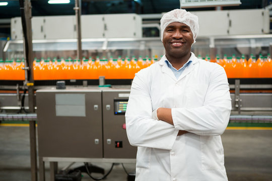 Confident male worker standing in juice factory