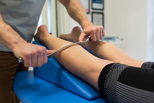 Physiotherapist giving leg massage to woman