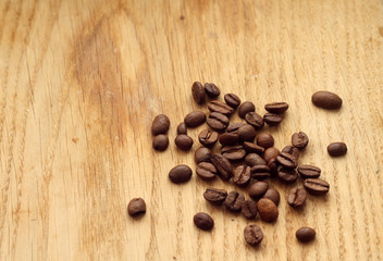 Coffee beans on wooden board with blur effect.